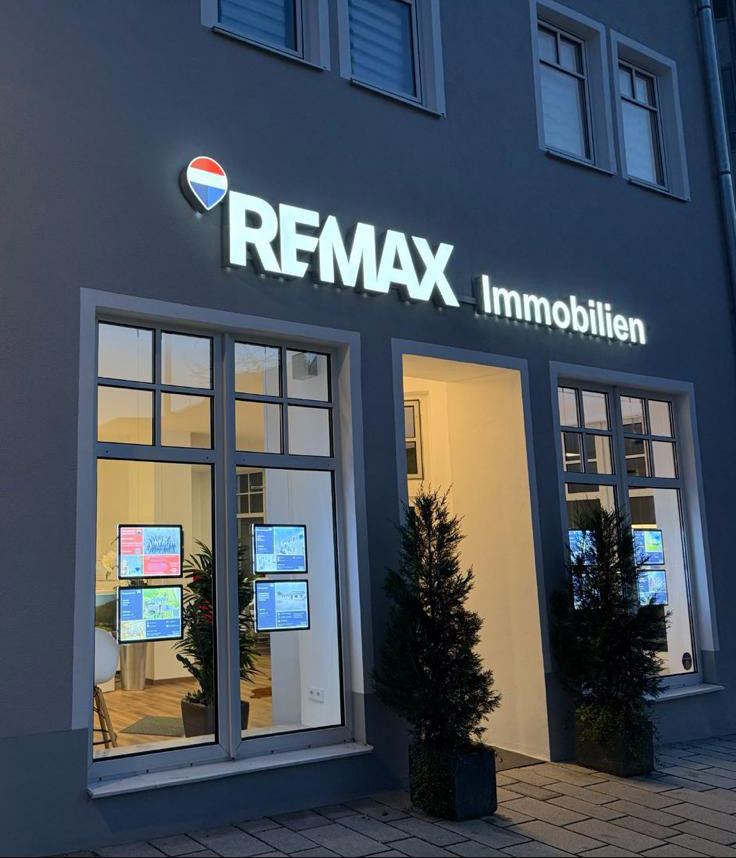 RE/MAX Immobilien Schwandorf Shop erleuchtet am Abend