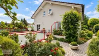 Gepflegtes Haus mit blühender Gartenterrasse