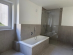Badezimmer mit Badewanne und Dusche - Einziehen und Wohlfühlen – ERSTBEZUG